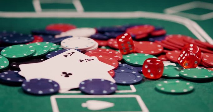 Close up of pocket rockets two aces on a heap of chips and rolling dice shot in 4k super slow motion