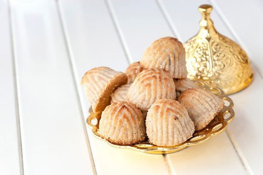 Maamoul traditional arab filled pastry or cookie with dates or cashew or walnut or almond or pistachios nuts. Eastern sweets. Close up. White wooden background.
