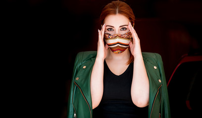Young woman in fashionable homemade mask, scarf on her face, stop virus, save yourself 