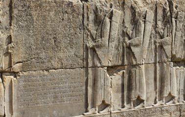 starożytne płaskorzeźby mężczyzn wykute w kamieniu na jednej ze ścian w persepolis w iranie © KOLA  STUDIO