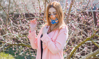 Young woman in fashionable homemade mask, scarf on her face, stop virus, save yourself 