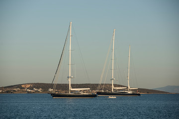 Dos hermosos veleros en un mar tranquilo en una isla griega. Grecia vacaciones de lujo.