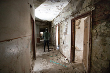 Fototapeta na wymiar Dramatic portrait of a man wearing a gas mask in a ruined building.