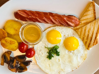 fried eggs with sausage and toast on a plate. flat lay style. Tasty breakfast