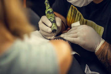 Girl getting tattoo on her arm