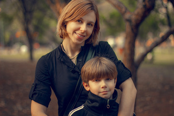 Mother and son posing in the park.