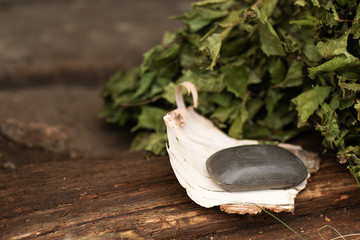 Tar soap lies on birch bark. Aged wooden background, birch leaves. Eco-friendly body care, disease...