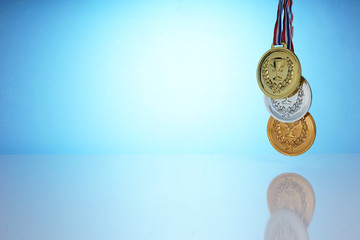 The gold, silver and bronze medal is a symbol of reward in every competition. The champion holds a colections of medal in his hand.