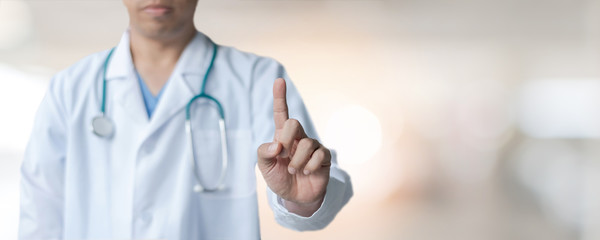 Medical doctor with pointing finger on  copy space or virtual screen technology on blur hospital background