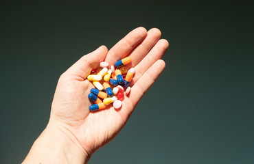 Colorful pills and medicines in the hand.