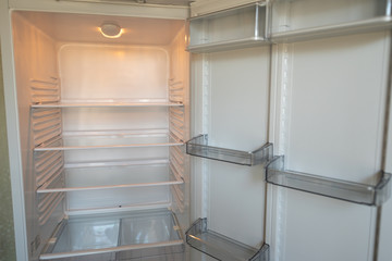 Fototapeta premium Empty shelves in refrigerator. The concept of diet and hunger