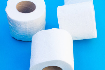 Toilet paper-Tissue paper roll. The reel of the toilet paper on the blue background. Roll of toilet paper- Cheap wc wiping paper product hygienic purposes.Rolls of toilet paper. Wc papers.N
