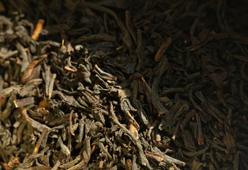 Black tea background. Dry tea leaves.