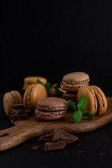 French macaroons on wooden table and black background. Selective focus 