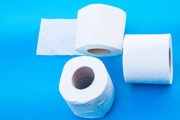 Toilet paper-Tissue paper roll. The reel of the toilet paper on the blue background. Roll of toilet paper- Cheap wc wiping paper product hygienic purposes.Rolls of toilet paper. Wc papers.N