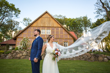 Beautiful wedding couple posing in the garden near barn