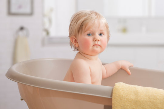 A Happy toddler bathing in bathtub.