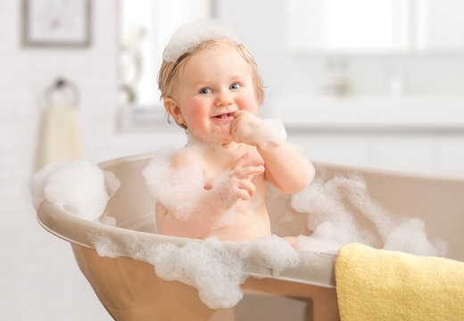 Child washing in a bathroom in foam.