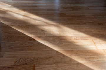 Sun ray or beam on wooden floor, sunlight lines shadow on parquet, interior with sunlight 