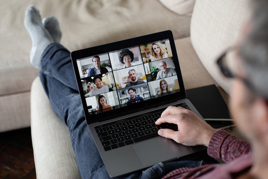 Person Using Video Conferencing technology sitting on sofa at home