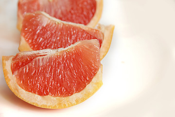 Fototapeta na wymiar juicy slices of red grapefruit close up on a white background