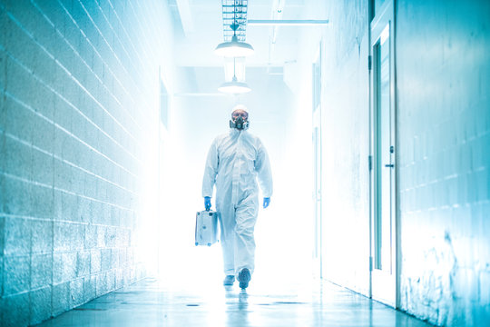 corona virus concept. male doctor waliking in coridor with biohazard case
