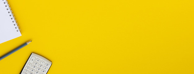 Office Style. Calculator, notepad and pencil on a yellow background, space for copy or text