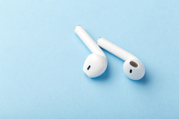  wireless bluetooth headphones lie on a blue background