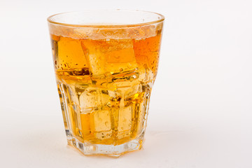 Glass of scotch whiskey and ice over white background.