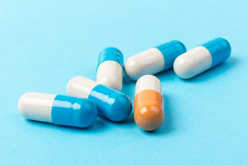 Pills isolated on blue background.Colorful medical drug capsule.