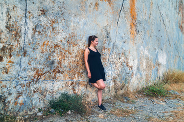 portrait of a young woman on a steep rock face