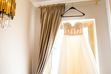 Beautiful wedding dress hanger on the window