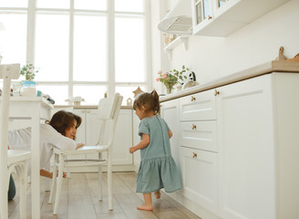 A young mother spends time with her little daughter at home.