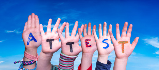 Children Hands Building Colorful German Word Attest Means Attestation. Blue Sky As Background