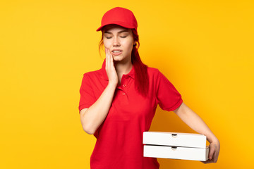 Pizza delivery girl holding a pizza over isolated background with toothache