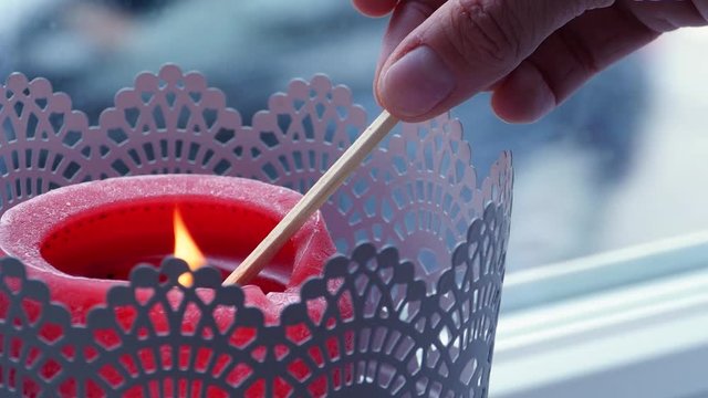 lighting up a red candle in the window