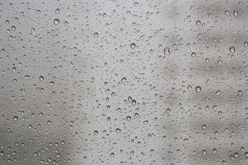 Raindrops trickle down the window