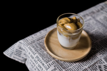 Iced Dalgona Coffee, a trendy korean style  cremy whipped coffee on fresh milk, on wooden tray on the table