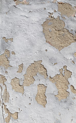 Close-up of a weathered and old concrete wall, white paint is peeling off. High resolution abstract full frame textured background.