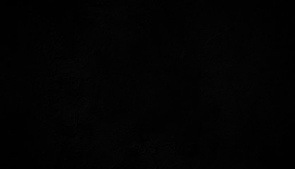 Close-up of a dark weathered and old concrete wall, paint is peeling off. Dark, almost black, high...