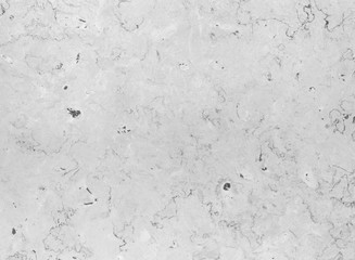 Close-up of an old and weathered marble stone wall. High resolution full frame textured background in black and white.