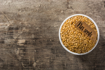 Golden flax seeds on wooden table top view. Copy space	