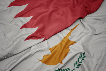 waving colorful flag of cyprus and national flag of bahrain.