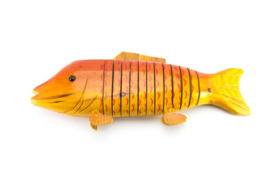 Light brown wooden fish on a white isolated background. Handmade carved from wood. An original souvenir for the fisherman.