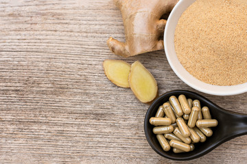 Ginger powder capsule on wood floor. top view.