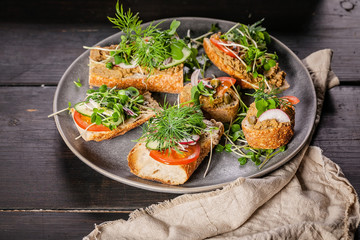 Italian traditional bruschettas and canapes with turkey pate, tomatoes, cucumbers and microgreens. Delicious homemade breakfast or snack.