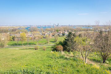 Scenic view from a hill of dutch countryside near lake "Zevenhuizerplas" and skyline of "Nesselande", a neighbourhood of Rotterdam, Netherlands.