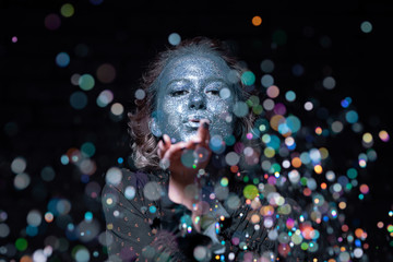 girl with a blue face in sparkles listens to photography tips from the photographer