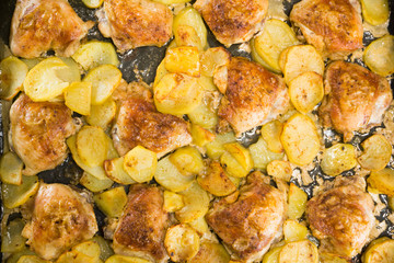 Roasted chicken meat with potatoes on a brow top view. Home lunch
