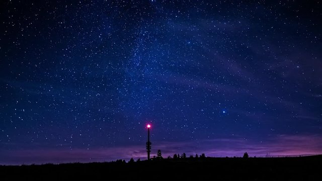 Timelapse of starry night sky in Feldberg, Germany. Illuminated Feldbergturm